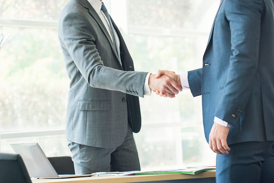 Businessmen shaking hands in office