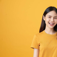 A girl in orange shirt in front of orange backdrop with orange photo on the phone