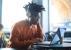 black woman writing on laptop at internet cafe