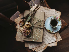 roses, old letters, and a cup of tea on a chair.