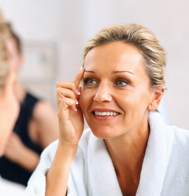 Woman applying skincare in mirror