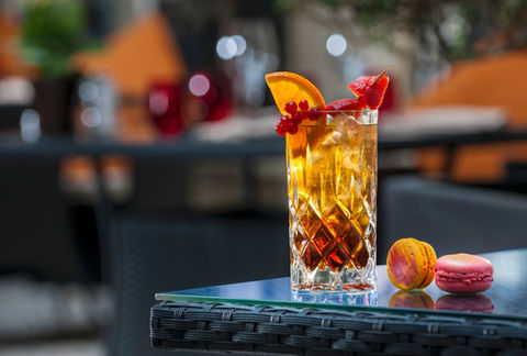 A refreshing cocktail in a glass, garnished with fresh fruits