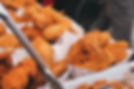 A close-up of crispy fried chicken wings piled in white baskets
