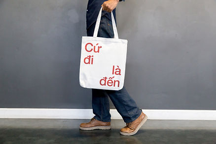Man holding a white canvas tote bag