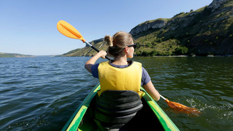 Woman kyaking on lake.