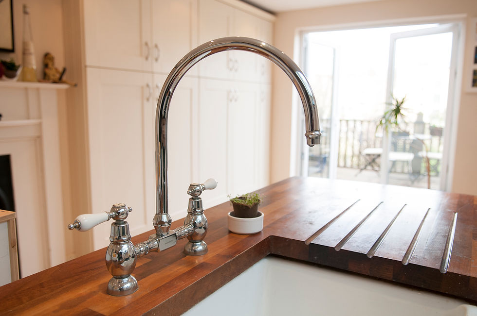 a traditional chrome bridge-style kitchen mixer tap featuring a high-arching swivel spout and white ceramic lever handles