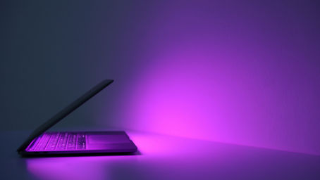 A purple laptop emitting a glow
