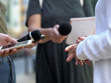 Hands holding a phone and microphones