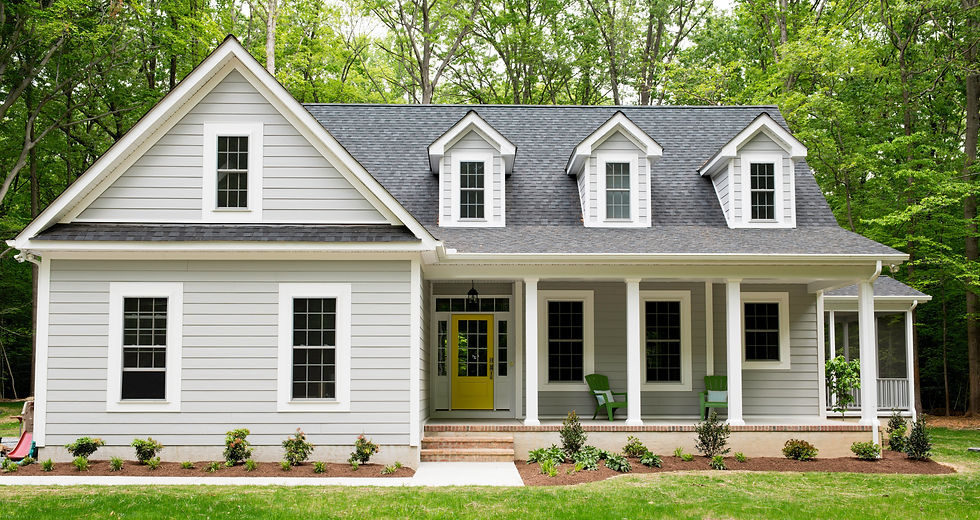 Large white timber-clad house featuring four front gables with grey roofing and a yellow front door
