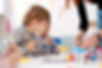 a photo of children painting with a teacher helping