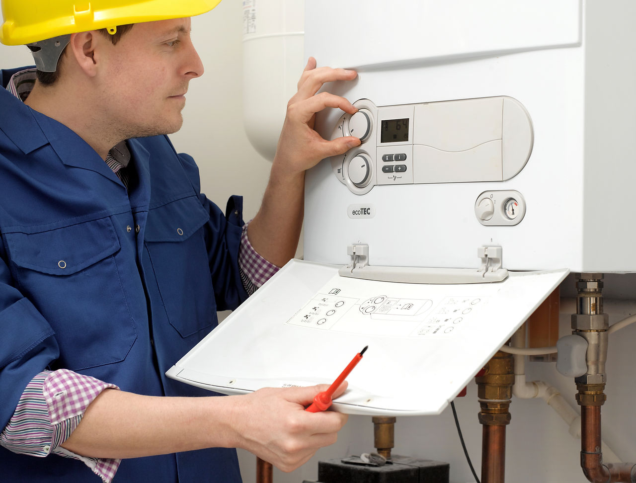 Plumber regulating the boiler