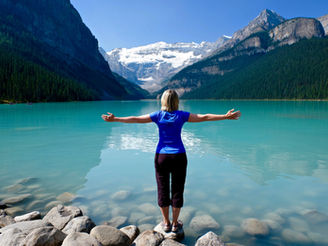Une femme qui lâche prise au bord d'un lac