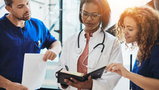 Three healthcare workers looking at notes