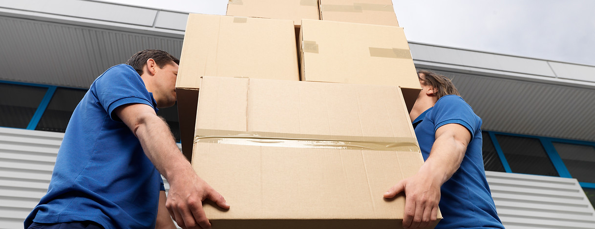 self storage facility worker carrying cardboard boxes