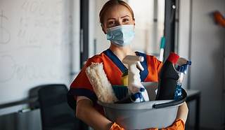 Person mit Reinigungsmitteln
