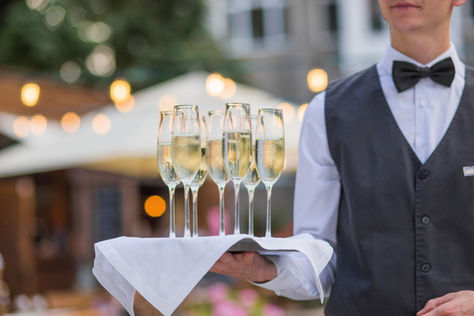 Champagne in glasses on a tray served by a waiter