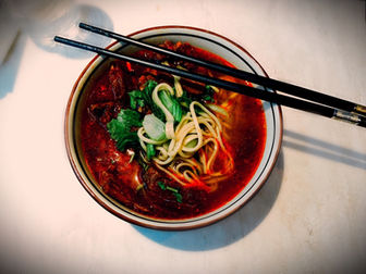 Bowl of hot udon noodles with meat and vegetables