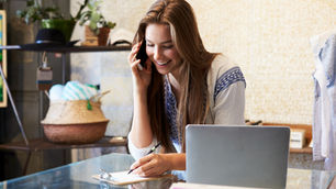 Business owner talking on the phone and writing down an order