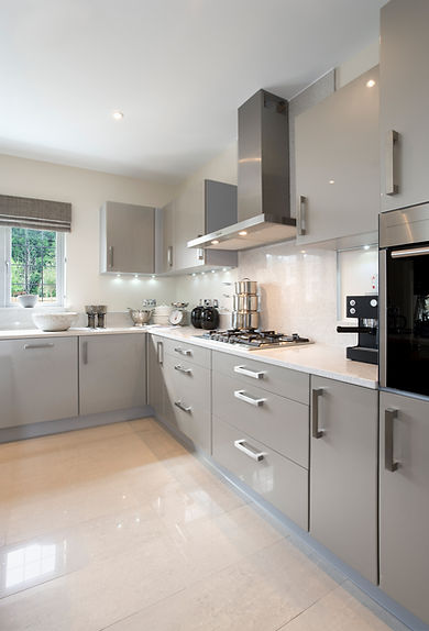 Modern grey kitchen corner with sleek cabinets and white countertops in a bright new build home