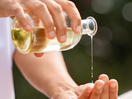 A man holding a glass bottle with a Carrier Oil.