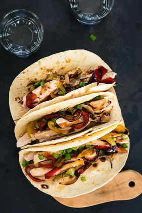 Two chicken fajita wraps with peppers and onions