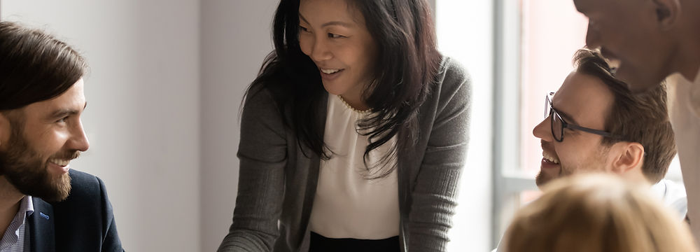 Asian business woman conducting meeting and laughing