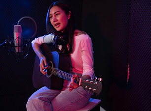 A woman singing and playing guitar