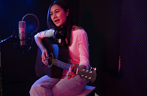 A woman singing and playing guitar