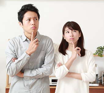 困った表情をした若いカップル
