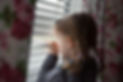 Girl looking through window