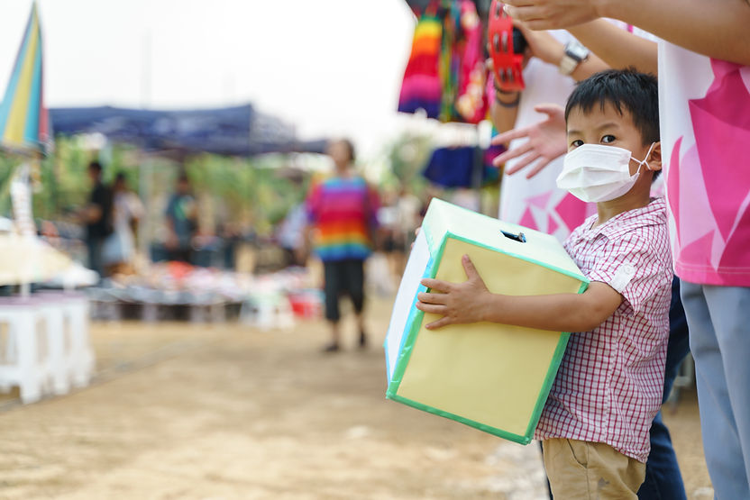 A boy holding a donation box