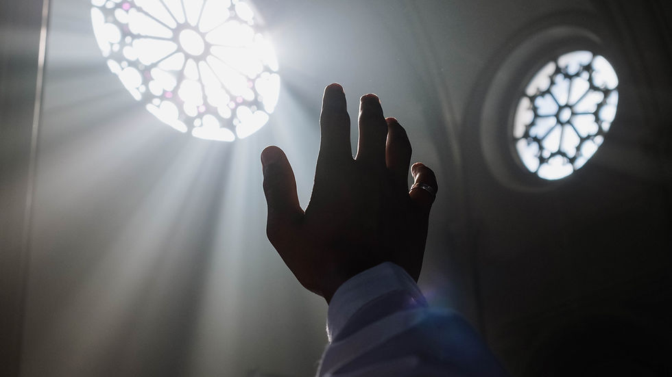Hand reaching toward a glowing light symbol on a wall, representing inner darkness, healing, and the journey toward emotional awareness and transformation.