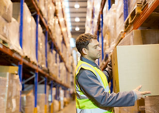 Worker stacking boxes in warehouse