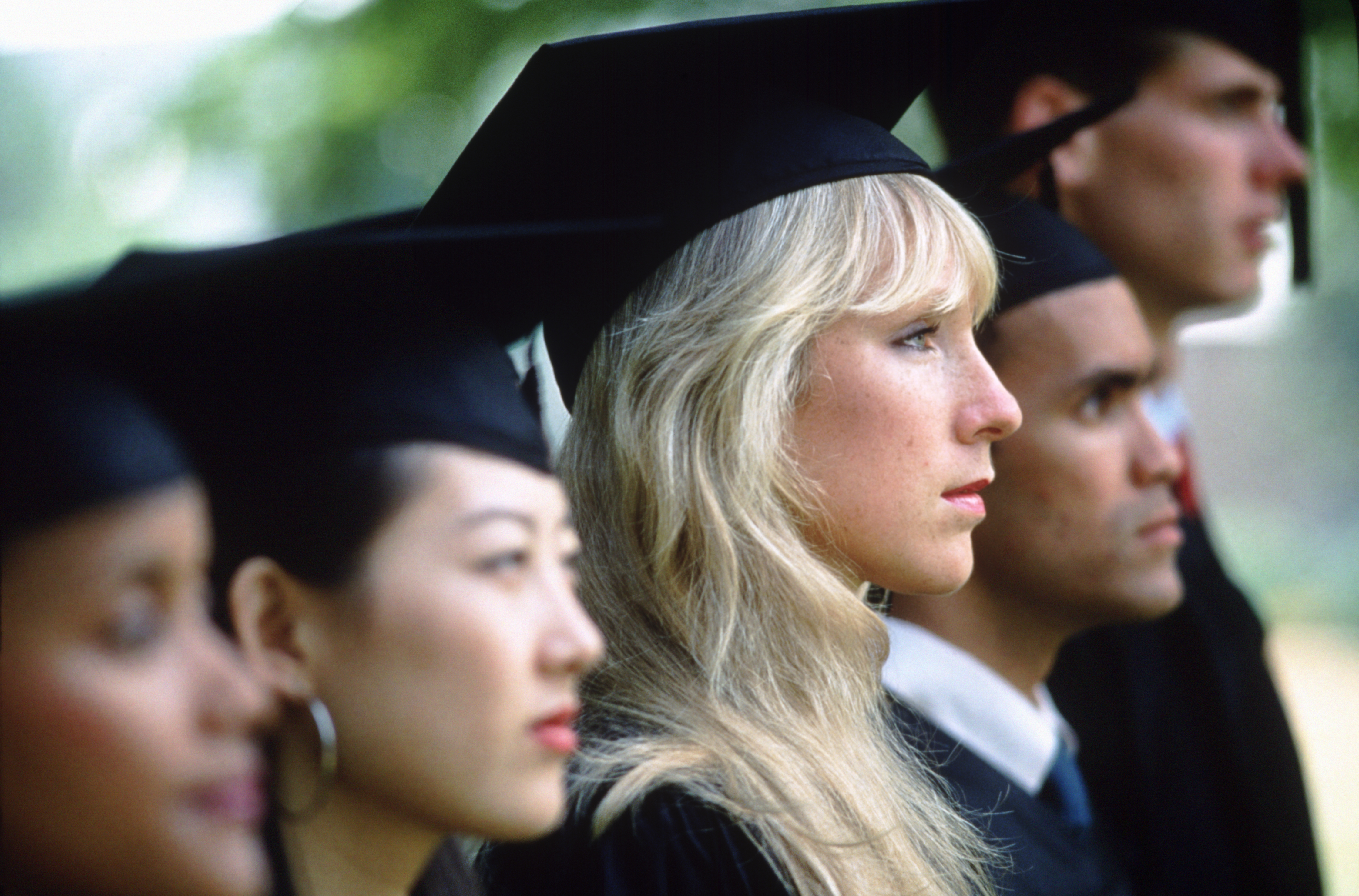 A diverse group of recent college graduates in caps and gowns, smiling and celebrating, symbolizing the culmination of their 