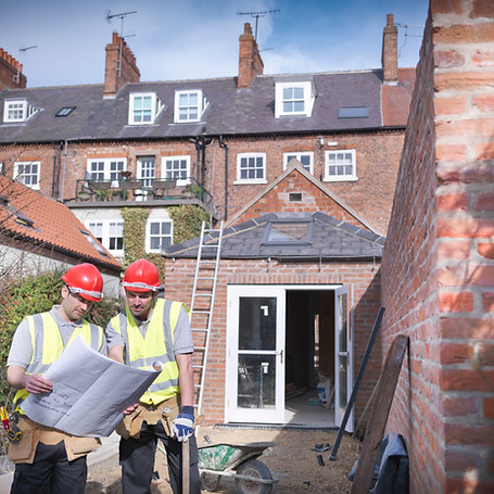 Builders outside house with plans