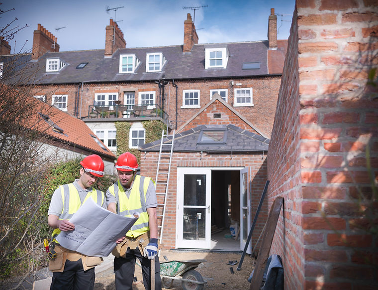 Builders outside house with plans