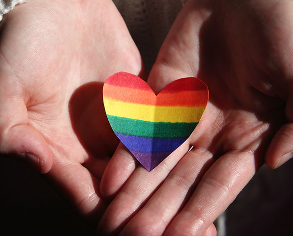 Two hands holding a heart, symbolising care and wellbeing