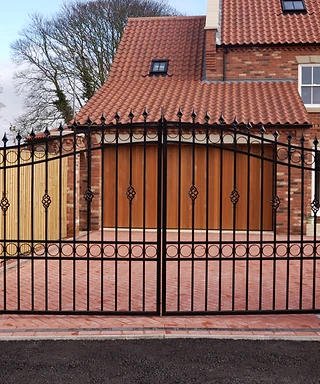 New garage and driveway behind an iron gate in a UK housing development
