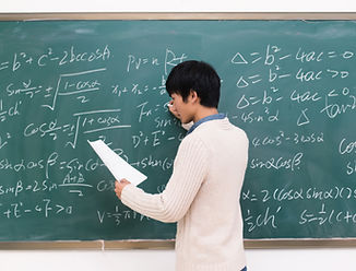 Asian teacher writing on chalkboard