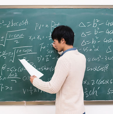 Asian Singapore teacher writing on chalkboard