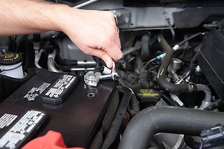 A professional repairing a car battery