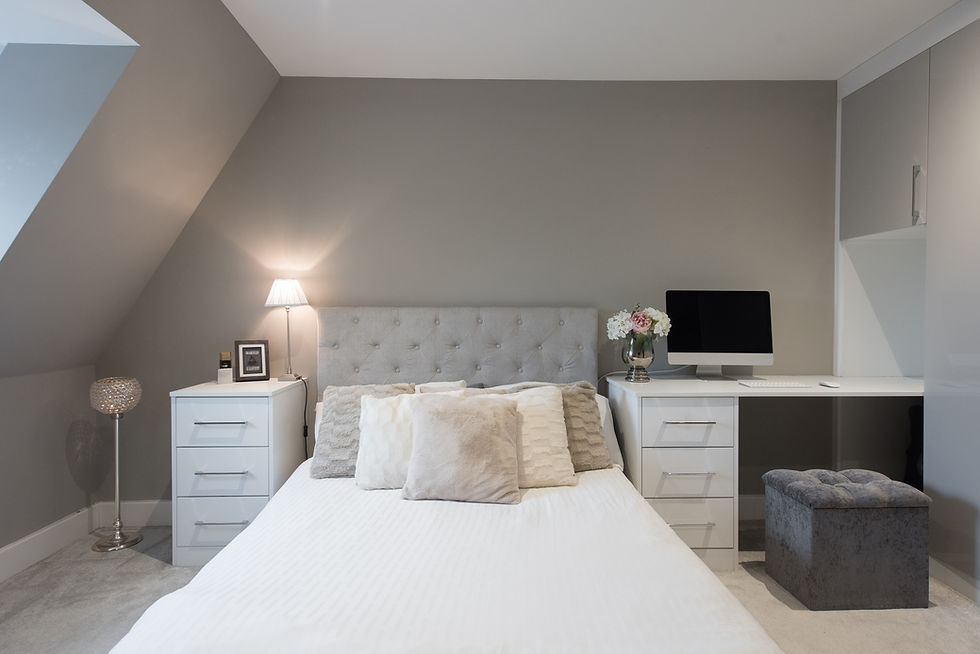 The grey tufted headboard adds a soft, elegant touch against the neutral wall