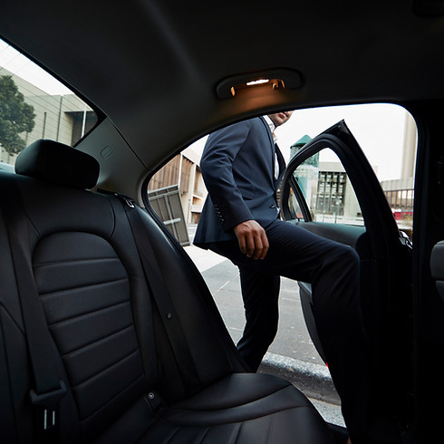 Businessman getting into backseat of exclusive cab