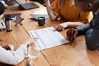 High angle view of business people discussing blueprint at conference table in office