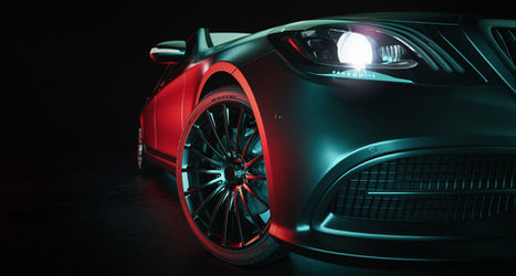 Sleek black car with glowing headlights, close-up view in the dark