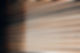 Close-up of wooden blinds partially open, allowing soft light to filter through