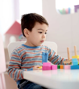 Toddler practicing fine motor skills with a hands-on play-based learning activity
