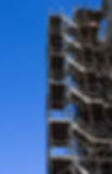 Scaffolding stairs up the side of a building with a nice blue sky in the background