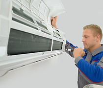 Technician servicing air conditioner
