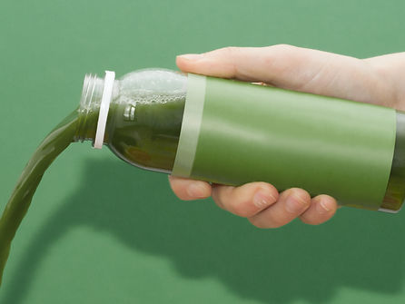 pouring green juice for detox
